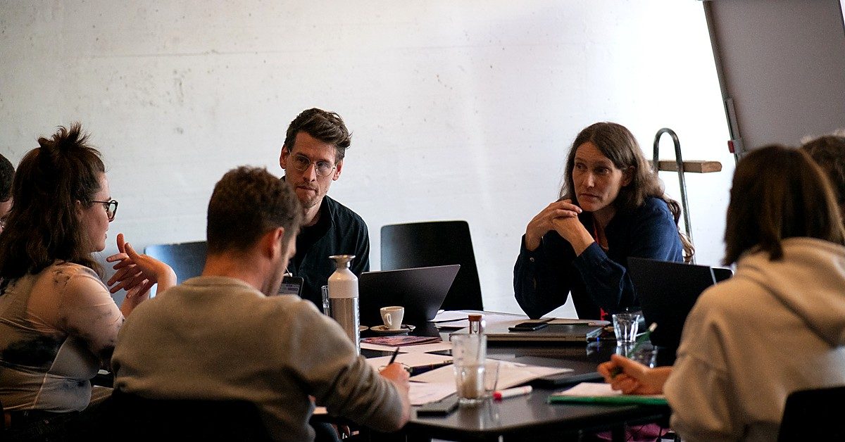 Zweier-Austausch im Writers Room: konzentrierte Arbeit an einem aktuellen Projekt